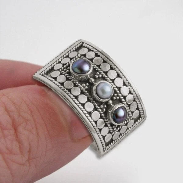 Eleganter geometrischer Ring mit kunstvoll geschnitzter Perle und funkelnden drei Steinen