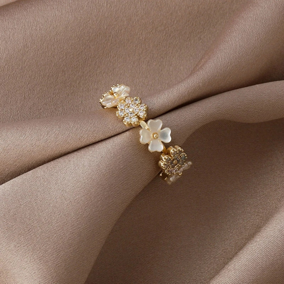 Eleganter verstellbarer Goldring mit weißen Blumen und funkelnden Zirkoniasteinchen
