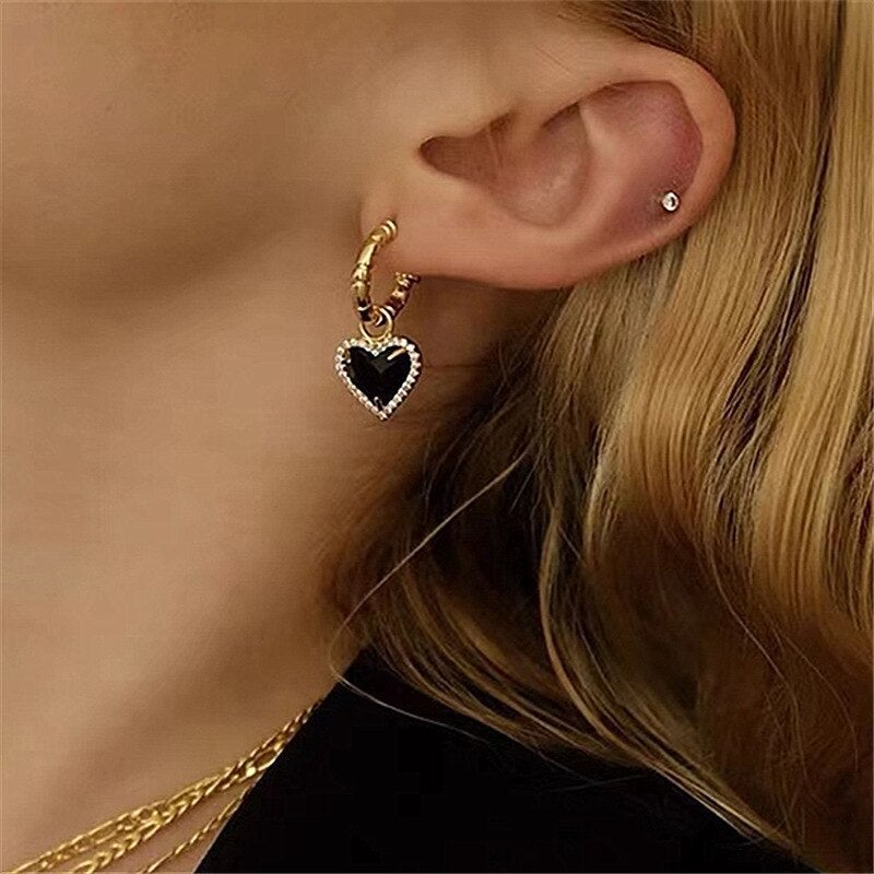 Elegante goldene Ohrstecker mit schwarzem Herzdesign