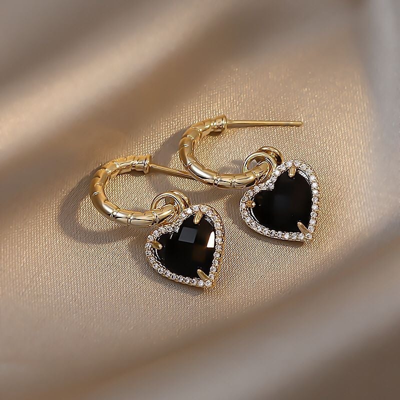 Elegante goldene Ohrstecker mit schwarzem Herzdesign