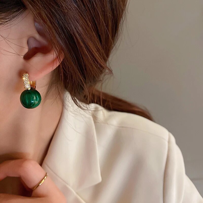 Elegante Goldohrringe mit strahlenden grünen Perlen