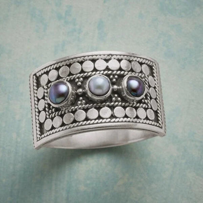 Eleganter geometrischer Ring mit kunstvoll geschnitzter Perle und funkelnden drei Steinen