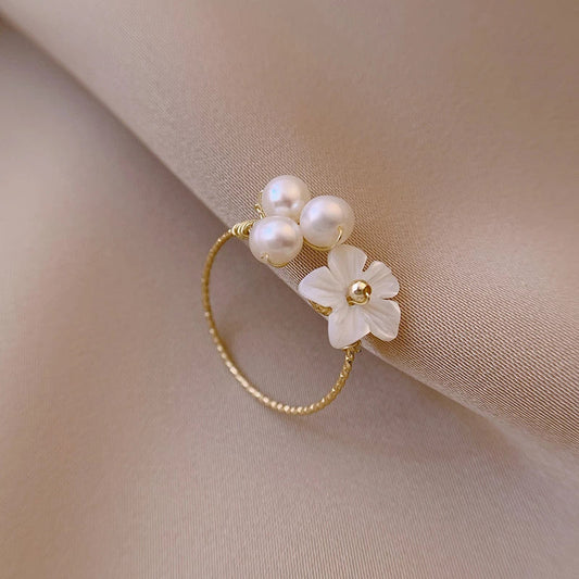 Eleganter Goldring mit Blütendesign und schimmernder Perlmuschel