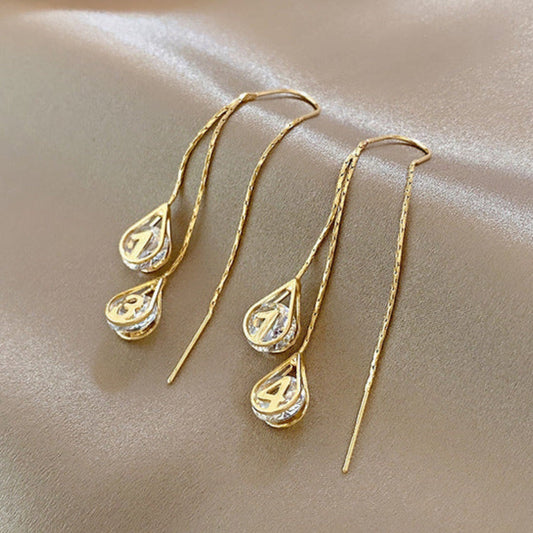 Elegante goldene nummerierte Ohrstecker