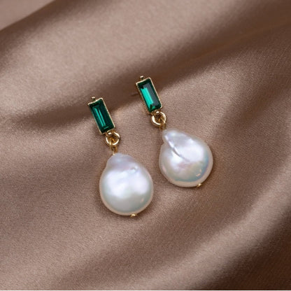 Elegante goldene Ohrringe mit funkelnden Perlen und edlen grünen Zirkonia