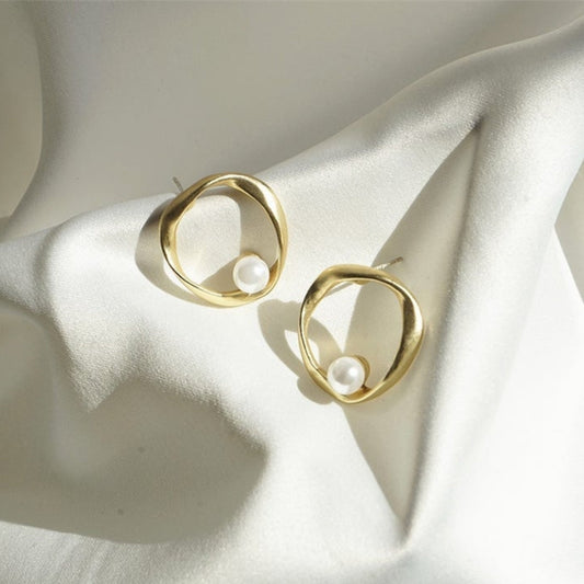 Elegante Goldohrringe mit wellenförmigem Design und Perlenakzenten