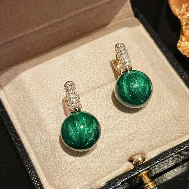 Elegante Goldohrringe mit strahlenden grünen Perlen