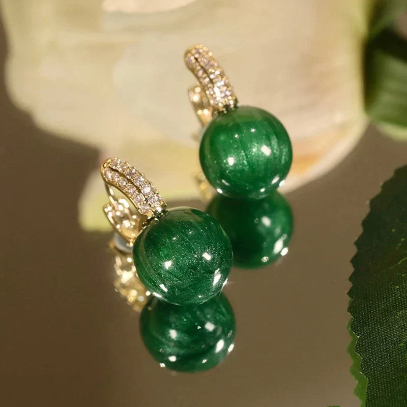Elegante Goldohrringe mit strahlenden grünen Perlen