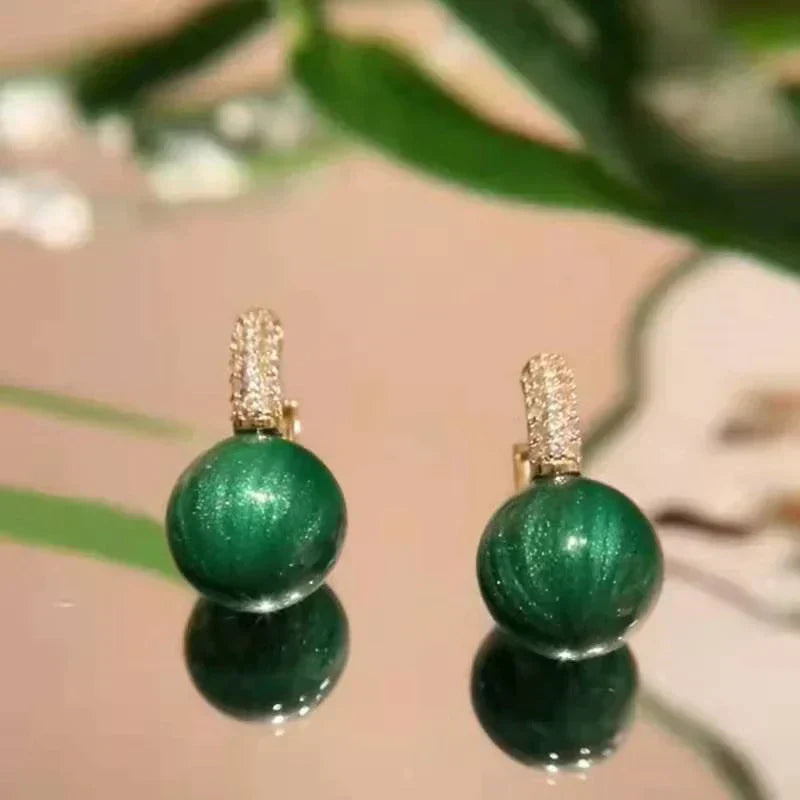 Elegante Goldohrringe mit strahlenden grünen Perlen