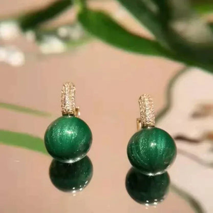 Elegante Goldohrringe mit strahlenden grünen Perlen