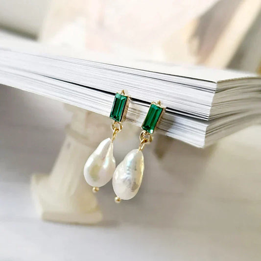 Elegante goldene Ohrringe mit funkelnden Perlen und edlen grünen Zirkonia