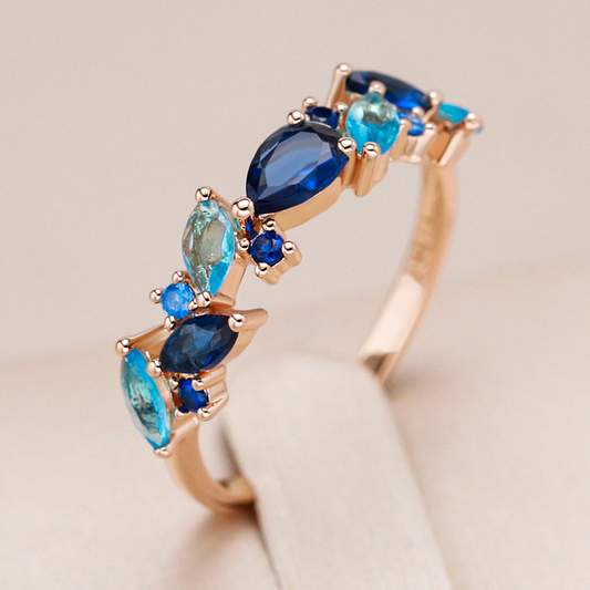 Stilvoller vergoldeter Ring mit funkelnden blauen Kristallen