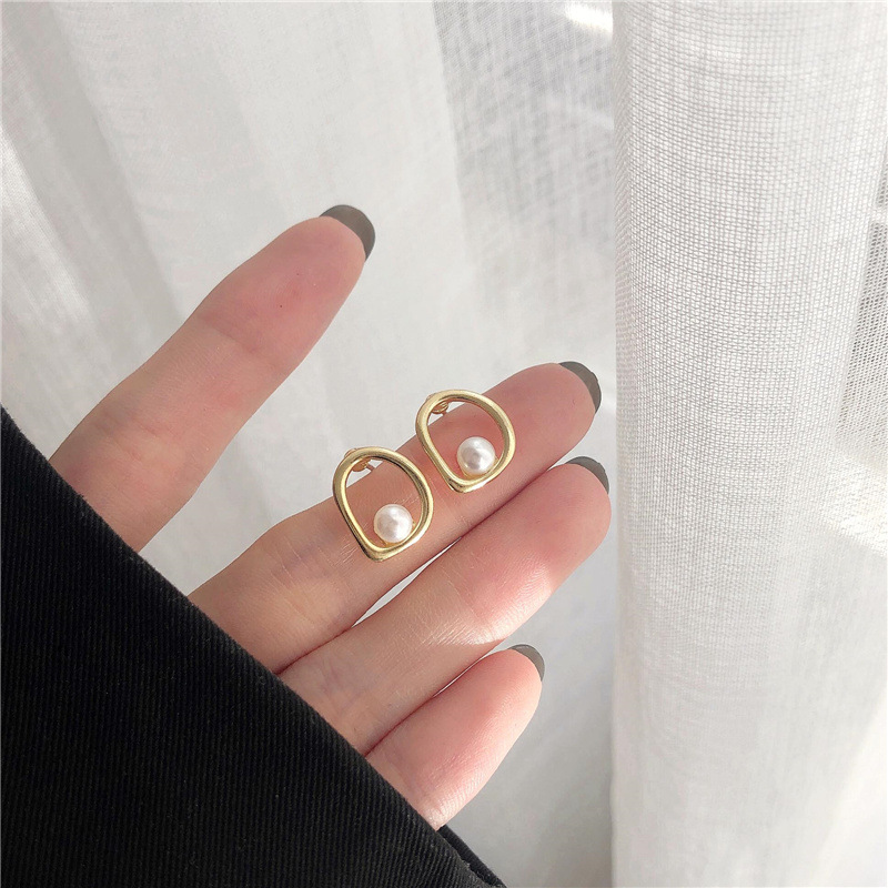 Elegante Goldohrringe mit wellenförmigem Design und Perlenakzenten